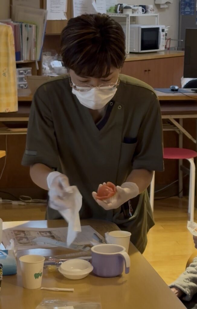 訪問歯科の口腔ケアで入れ歯のお手入れを説明する衛生士